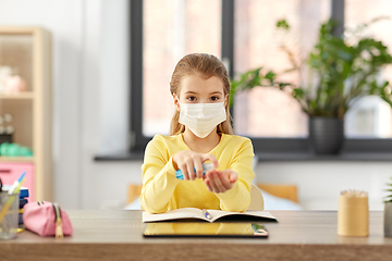 Image showing sick girl in mask with hand sanitizer at home