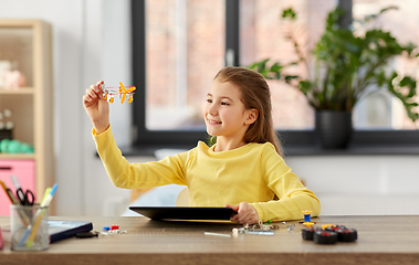 Image showing girl with tablet pc and robotics kit at home