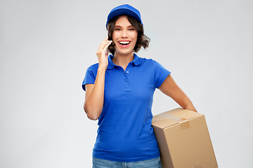 Image showing delivery girl with parcel box calls on smartphone