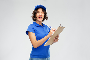 Image showing happy delivery girl with clipboard and pen writing