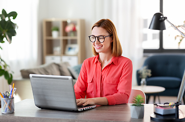 Image showing happy woman with laptop working at home office