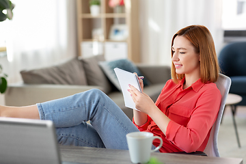 Image showing woman with notebook and laptop at home office