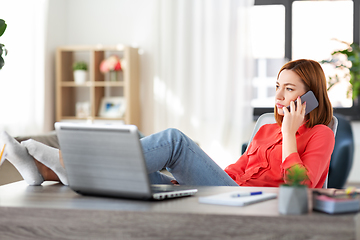 Image showing woman calling on smartphone at home office