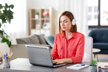 Image showing woman in headphones with laptop working at home