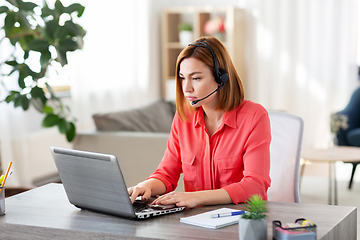 Image showing woman with headset and laptop working at home