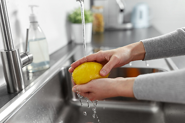 Image showing close up of woman washing lemon fruit in kitchen