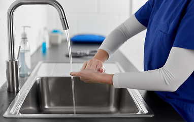 Image showing doctor or nurse washing hands with liquid soap