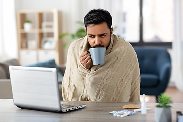 Image showing ill indian man in blanket drinking hot tea at home