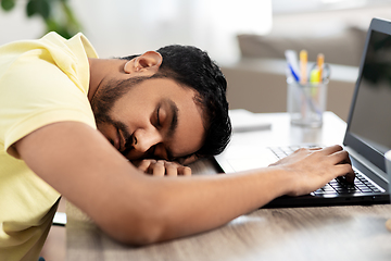 Image showing indian man sleeping on table with laptop at home