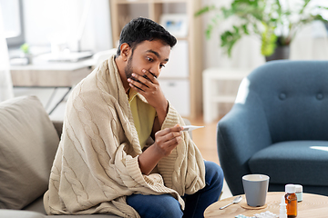 Image showing sick man measuring temperature by thermometer