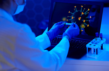 Image showing hand holding beaker with coronavirus blood test