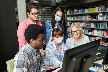 Image showing students in medical masks with computer at library
