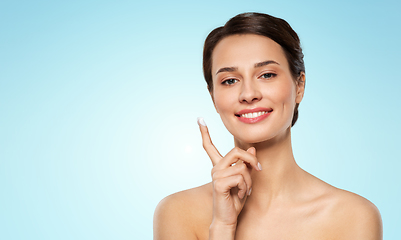 Image showing young woman with moisturizing cream on finger