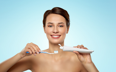 Image showing smiling woman with toothbrush cleaning teeth