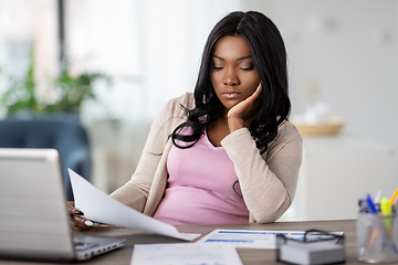 Image showing bored woman with papers working at home office