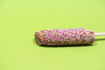 Image showing Ice cream on stick with colorful sprinkles