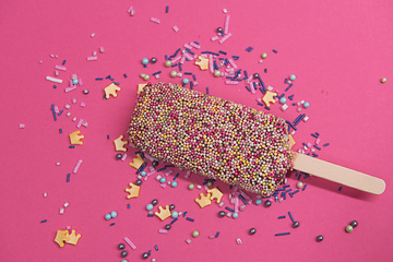 Image showing Ice cream on stick with colorful sprinkles