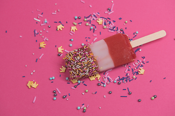 Image showing Ice cream on stick with colorful sprinkles