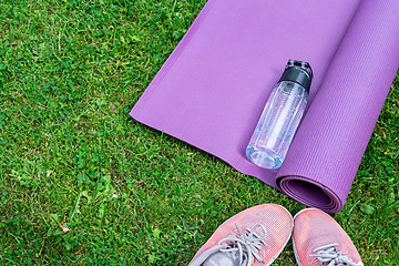 Image showing Sneakers, water bottle and a purple fitness mat. Sport concept