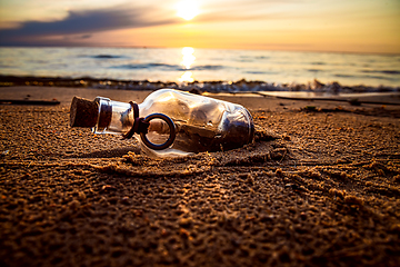 Image showing Message in the bottle against the Sun setting down