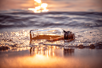 Image showing Message in the bottle against the Sun setting down