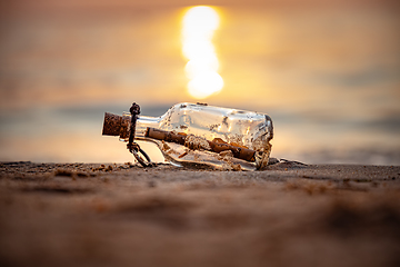 Image showing Message in the bottle against the Sun setting down