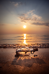 Image showing Message in the bottle against the Sun setting down