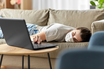 Image showing sick bored woman with laptop lying on sofa at home