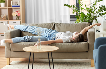 Image showing sick woman in medical mask lying on sofa at home