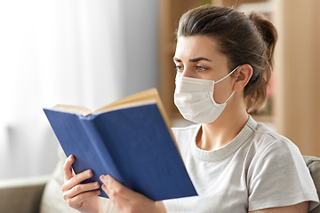 Image showing sick woman in medical mask reading book at home