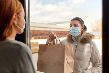 Image showing woman in medical mask delivers food for her friend