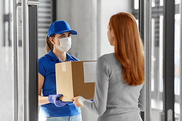 Image showing delivery girl in face mask giving parcel to woman