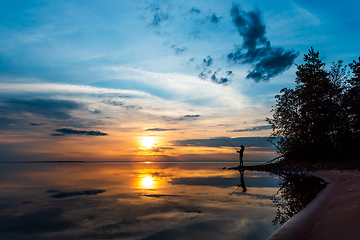 Image showing Woman fishing on Fishing rod spinning in Finland at sunset.