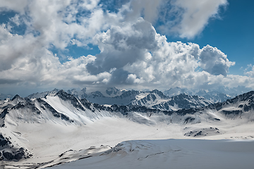 Image showing Mountain clouds over beautiful snow-capped peaks of mountains an