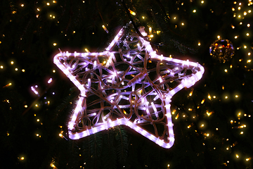 Image showing Bright beautiful glowing star on a Christmas tree in the evening