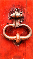 Image showing Vintage bright red wooden door with metallic doorhandle