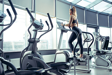 Image showing The female athlete training hard in the gym. Fitness and healthy life concept.