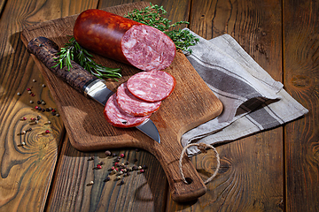 Image showing Sausage And The Knife On An Old Wooden Desk