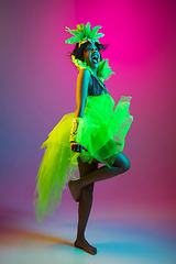 Image showing Beautiful young woman in carnival and masquerade costume on gradient studio background in neon light