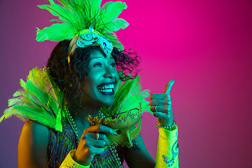 Image showing Beautiful young woman in carnival and masquerade costume on gradient studio background in neon light