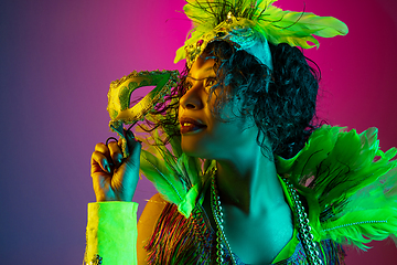 Image showing Beautiful young woman in carnival and masquerade costume on gradient studio background in neon light