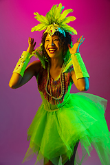 Image showing Beautiful young woman in carnival and masquerade costume on gradient studio background in neon light