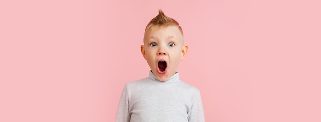 Image showing Happy boy isolated on pink studio background. Looks happy, cheerful, sincere. Copyspace. Childhood, education, emotions concept