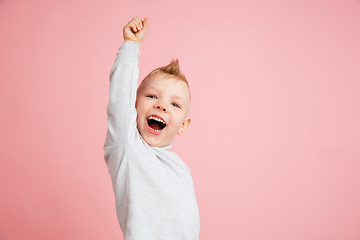 Image showing Happy boy isolated on pink studio background. Looks happy, cheerful, sincere. Copyspace. Childhood, education, emotions concept