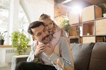 Image showing Happy father and little cute daughter at home. Family time, togehterness, parenting and happy childhood concept. Weekend with sincere emotions.