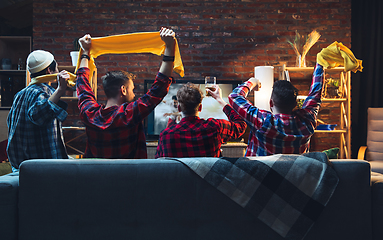 Image showing Group of friends watching TV, sport match together. Emotional fans cheering for favourite team, watching on exciting game. Concept of friendship, leisure activity, emotions