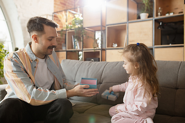 Image showing Happy father and little cute daughter at home. Family time, togehterness, parenting and happy childhood concept. Weekend with sincere emotions.