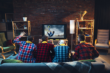 Image showing Group of friends watching TV, sport match together. Emotional fans cheering for favourite team, watching on exciting game. Concept of friendship, leisure activity, emotions