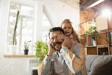 Image showing Happy father and little cute daughter at home. Family time, togehterness, parenting and happy childhood concept. Weekend with sincere emotions.