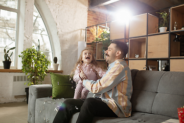 Image showing Happy father and little cute daughter at home. Family time, togehterness, parenting and happy childhood concept. Weekend with sincere emotions.